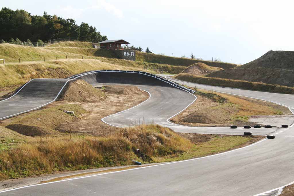 Asphaltierte Kurven und hügeliges Gelände: Streckenbau-Projekt am Erzgebirgsring Lichtenberg durch Wolf Straßenbau.
