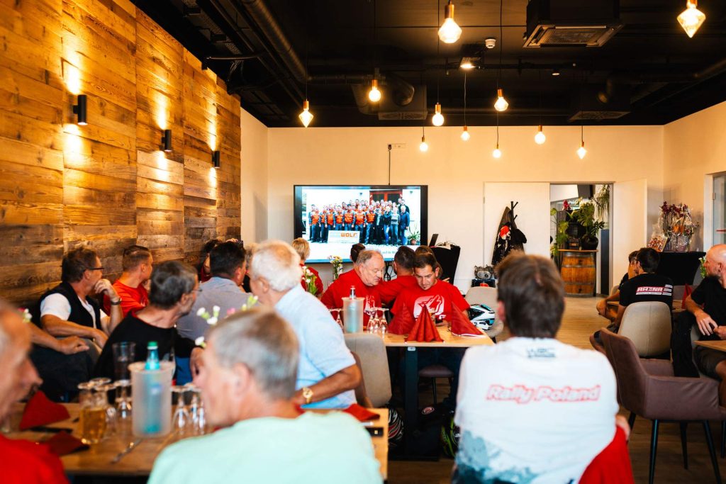 Mitarbeiter von Wolf sitzen am Tisch in der racing Lounge der Arena E