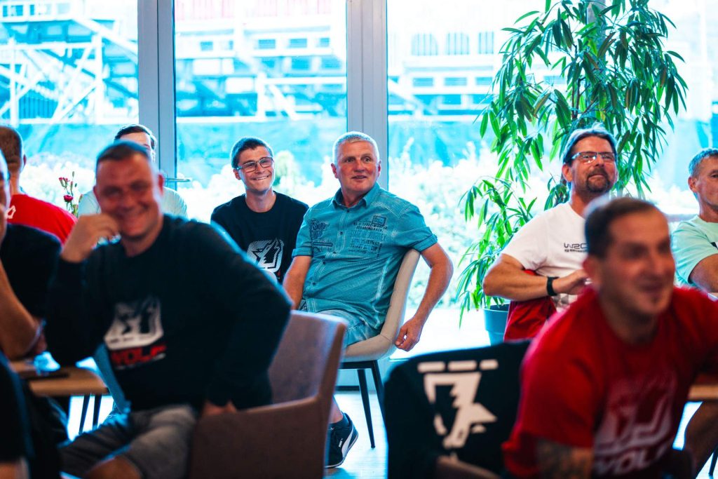 Mitarbeiter von Wolf sitzen am Tisch, schauen auf Susann Wolf, welce eine Rede hält