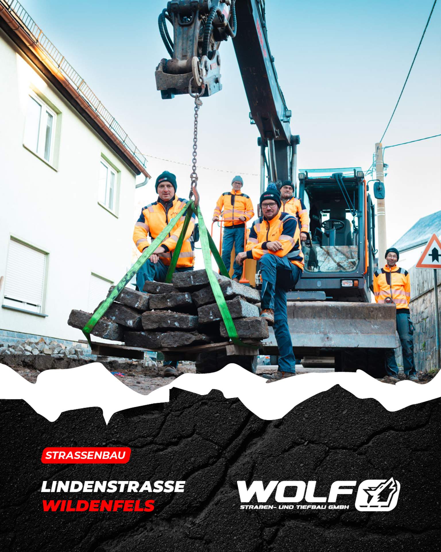 Das Team der Wolf Straßen- und Tiefbau GmbH nach Abschluss der Sanierung in Wildenfels. Im Hintergrund sieht man einen Kettenbagger und die neu asphaltierte Lindenstraße, auf der rund 3.000 m² Fläche modernisiert wurden.