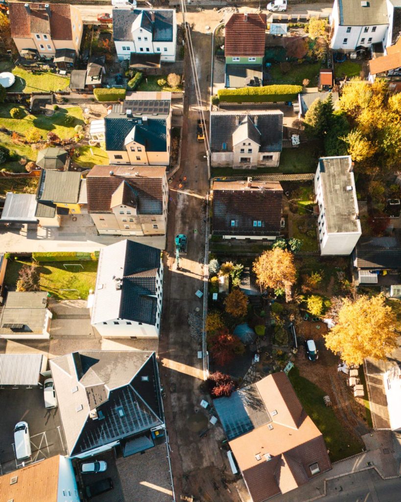 Drohnenaufnahme der Baustelle Ziegelstraße in einer Wohnsiedlung mit Blick auf die Sanierung einer schmalen Zufahrtsstraße und umliegende Häuser.